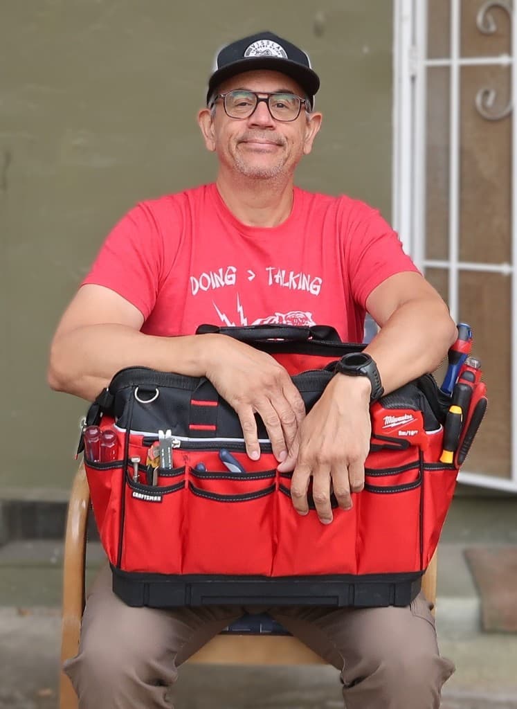 Wil of Wil's Home Works sitting with a tool bag, ready for local handyman jobs